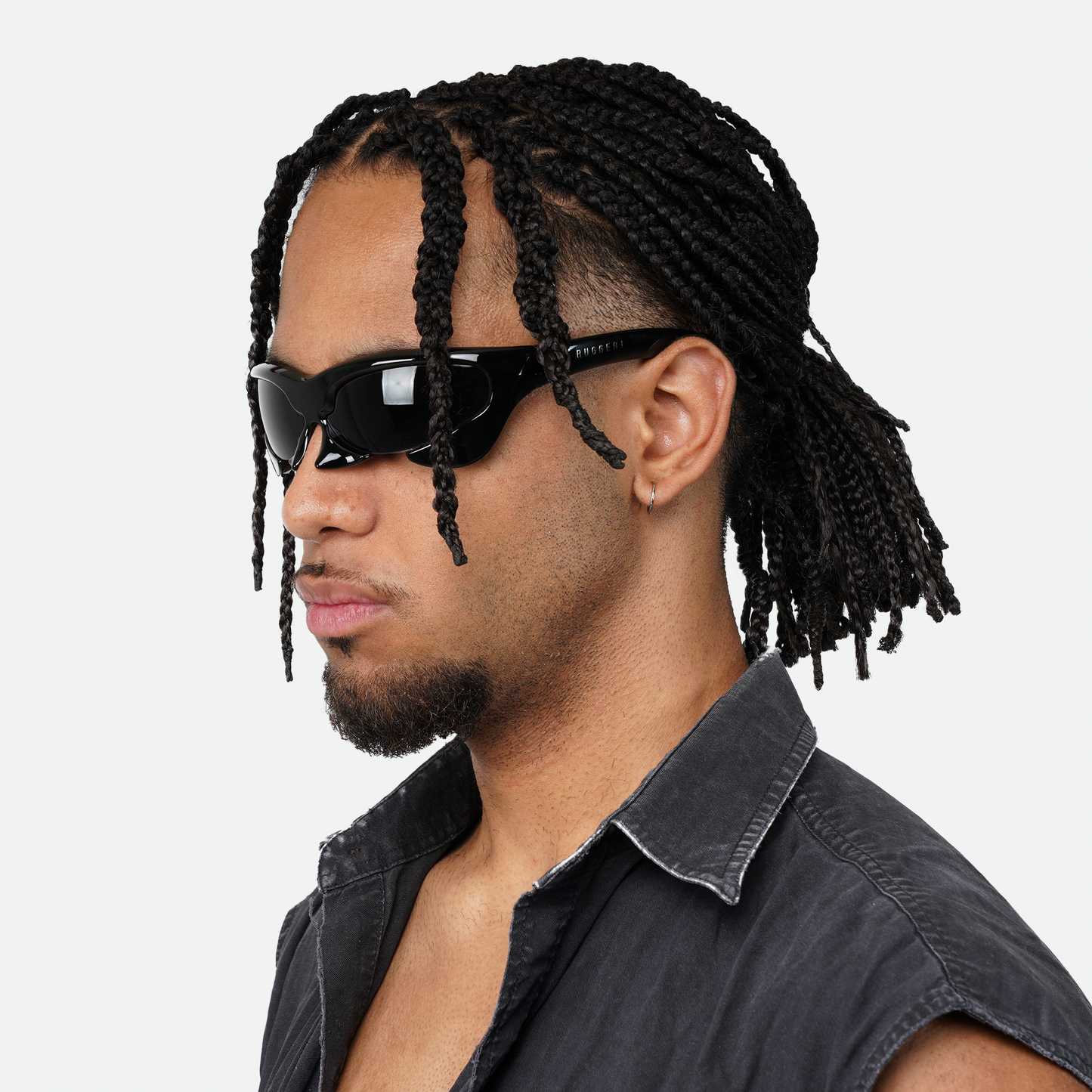 Male model showcasing Ruggeri Carapace sunglasses in all black, highlighting the sleek and bold custom-moulded insectoid design with black lenses.