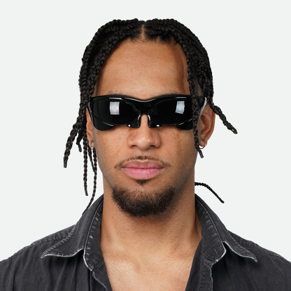 Front view of male model wearing Ruggeri Carapace sunglasses in all black, emphasizing the unique custom-moulded insectoid appearance with black lenses.