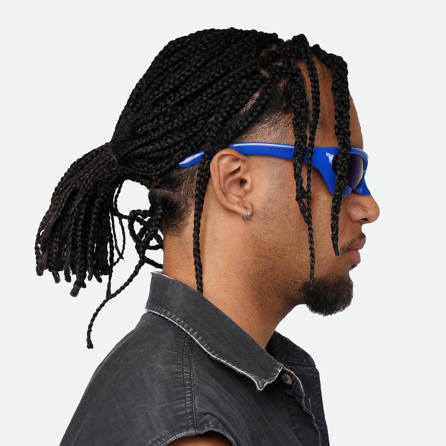 Side view of male model wearing Ruggeri Carapace sunglasses in vivid blue, showcasing the sleek custom-moulded insectoid design with Category 3 UV400 REVO lenses.