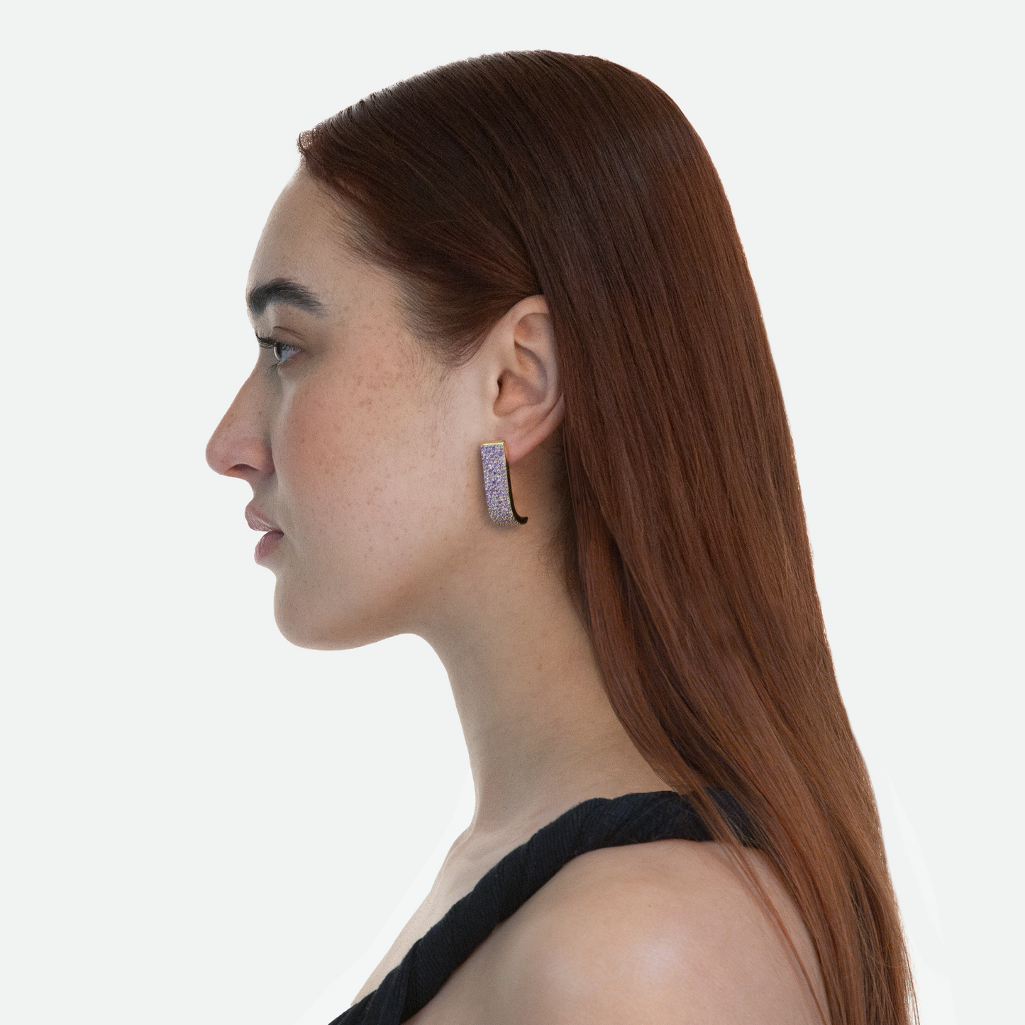 Side profile of model wearing the Lucci earrings that catch light from every angle, highlighting the over 180 cubic zirconia crystals on a white background.