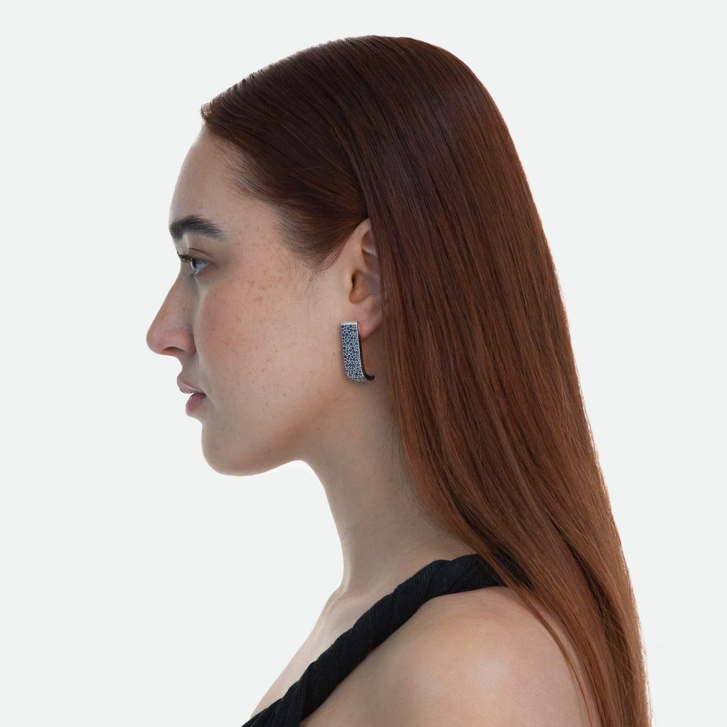 Side profile of model wearing the Silver Lucci earrings that catch light from every angle, emphasizing the over 180 cubic zirconia crystals on a white background.