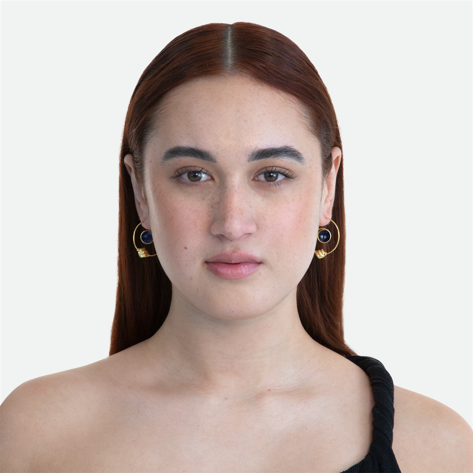 Model showcasing the Orbit earrings, featuring a Sodalite stone and bead combo within a gold plated arc, reflecting celestial pairings, on a white background.