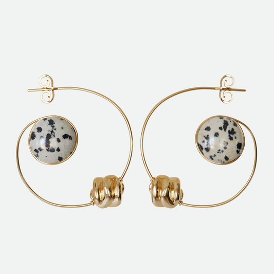 Orbit earrings with Dalmatian Jasper stone and bead hanging within a gold plated arc, evoking a planet and its moon, designed by Ruggeri.