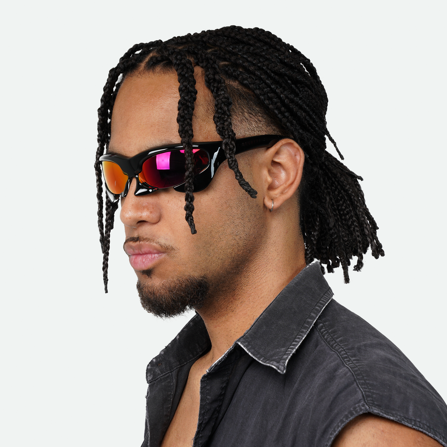 Male model showcasing Ruggeri Carapace sunglasses with black frames and striking red lenses, highlighting the sleek and bold custom-moulded insectoid design with Category 3 UV400 REVO lenses.