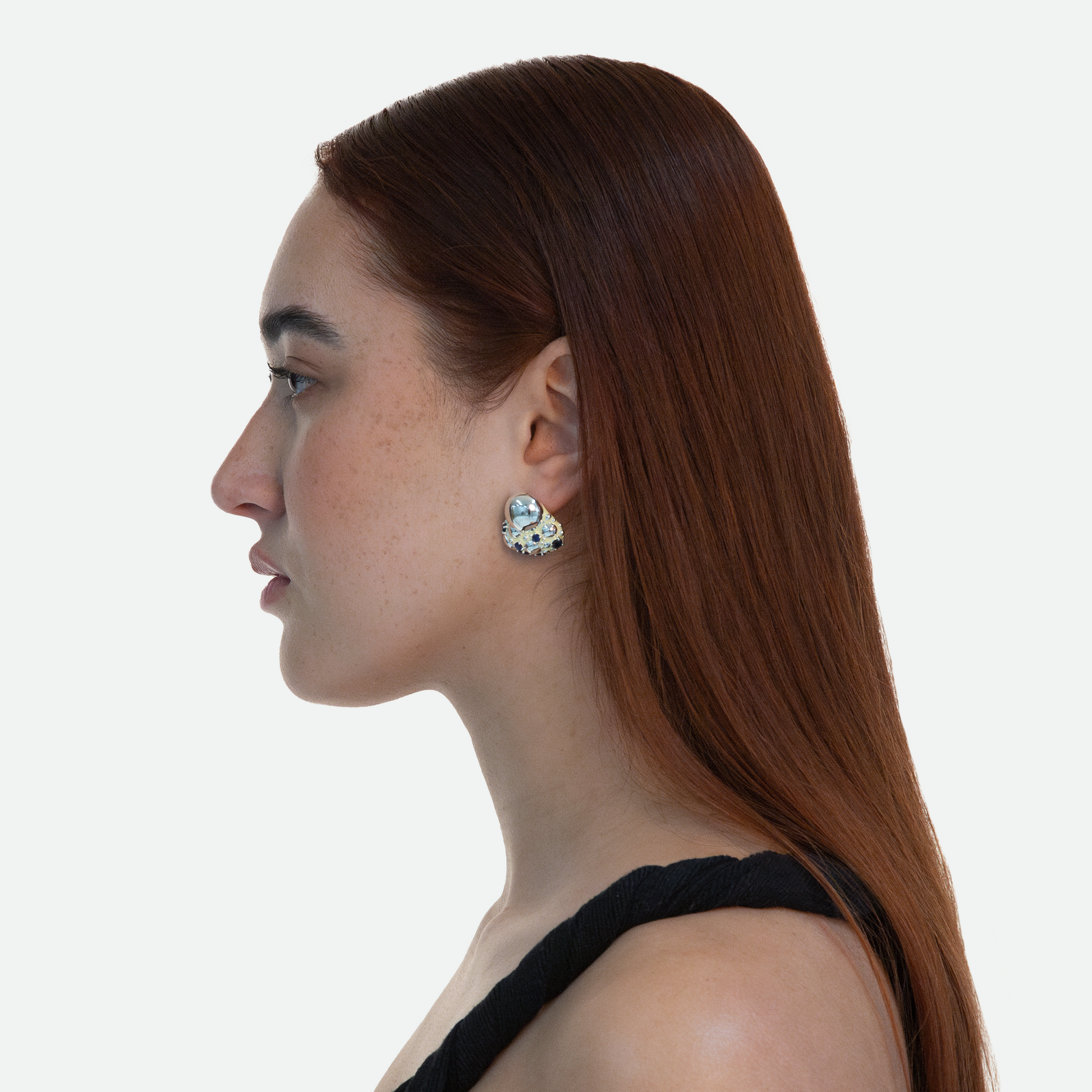 Side profile of model showcasing Ribolle earrings with abstract design and sapphire cubic zirconia crystals, designed in Western Australia by Ruggeri.