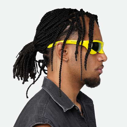Side view of male model wearing Ruggeri Carapace sunglasses with yellow frames and vibrant blue/orange lenses, showcasing the sleek custom-moulded insectoid design with Category 3 UV400 REVO lenses.